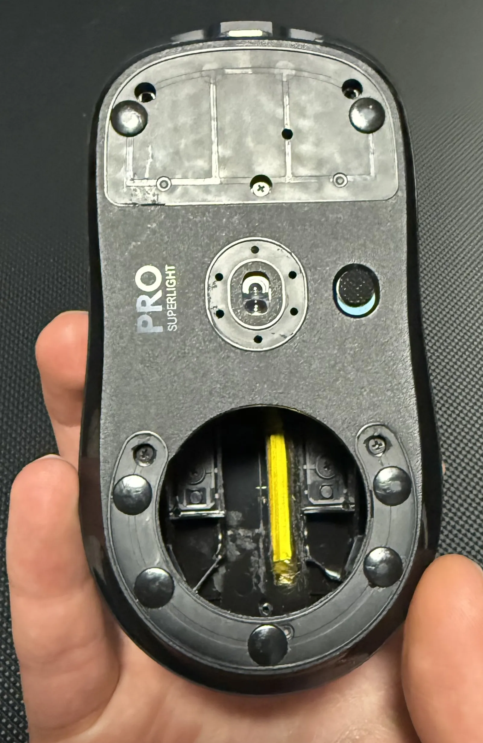 bottom side of superlight mouse with skates and cut out bottom for weight